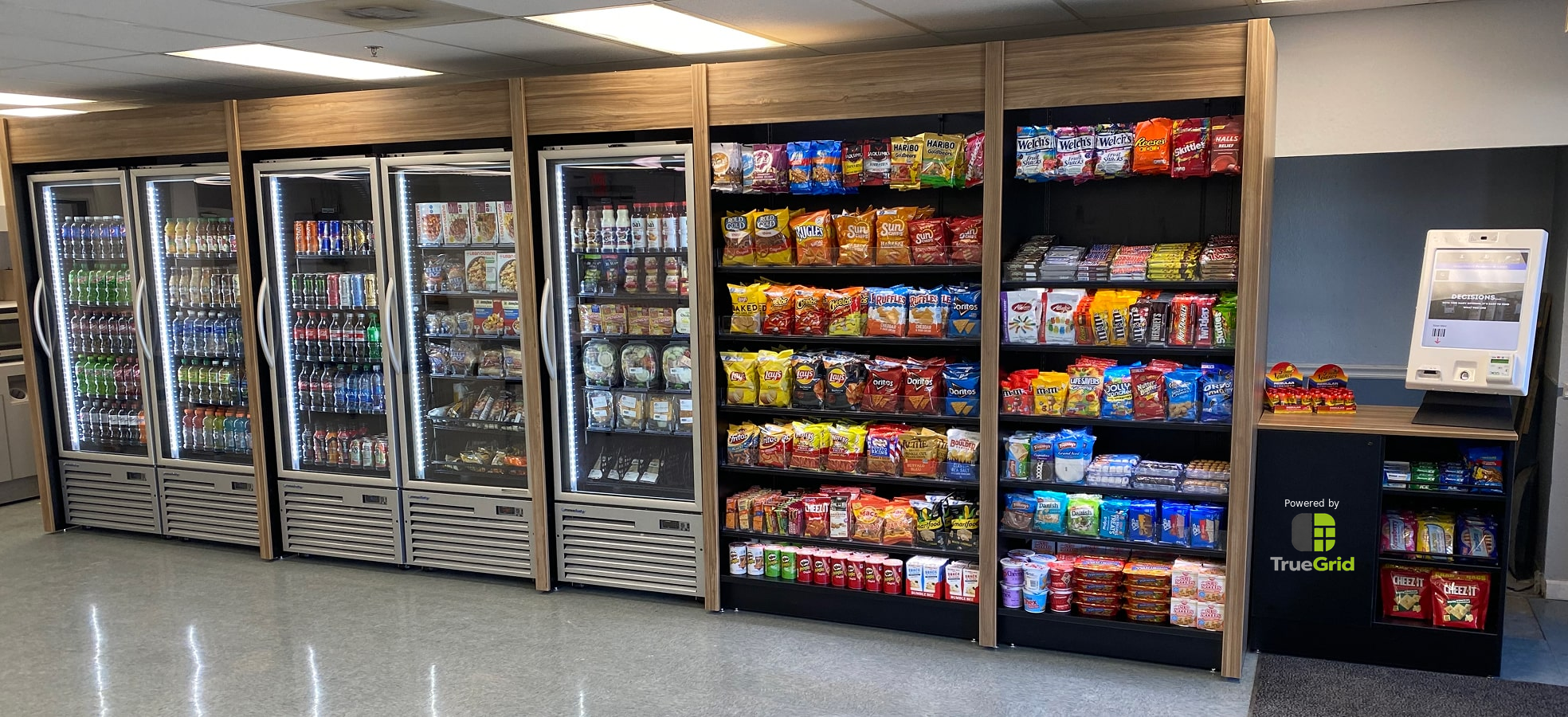 TrueGrid micro-market with coolers, shelves, snacks, drinks, and checkout kiosk